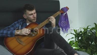他在家弹吉他。 吉他手练习吉他
